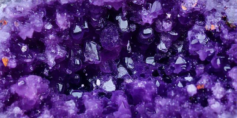 Pürüzlü, cilalanmamış bir Ametist jeodunun yakın çekim makro görüntüsü, derin mor kristallerini ve parıldayan inklüzyonları ortaya çıkarıyor.