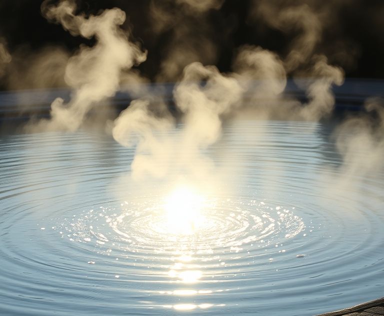 A sunlit pool with steam rising in the early morning light.