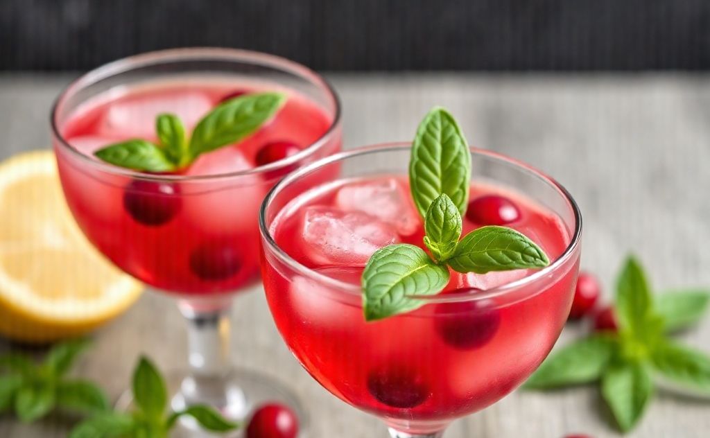 Cranberry cocktails garnished with fresh basil leaves.