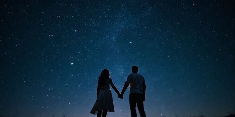 Yıldızlı gökyüzü altında el ele tutuşan çift